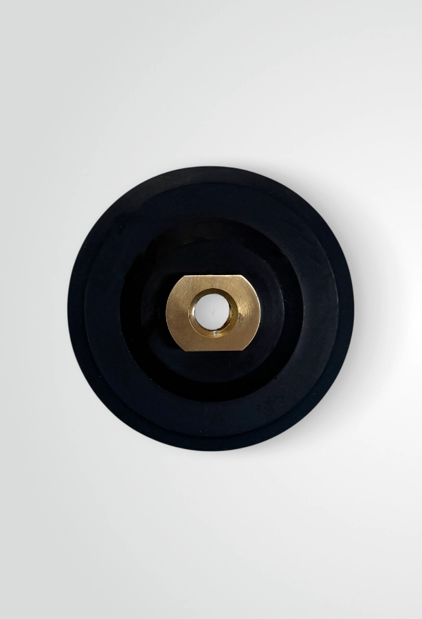 Na zdjęciu widoczny jest pad holder gumowy z elastyczną, okrągłą podstawą i centralnym gwintem, przeznaczony do mocowania tarcz polerskich przy pracy z szlifierką lub wiertarką.